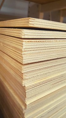 Depoda istiflenmiş kontrplak çarşafları var. Dikey