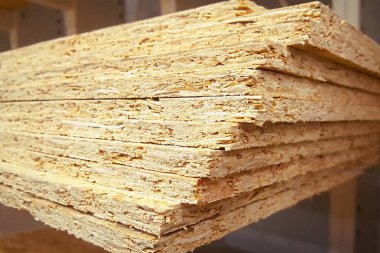 Üst üste yığılmış bir yığın OSB kağıdı. Kereste depodaki süpermarkette satılıyor..