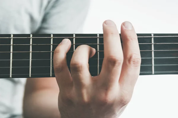 Mano maschile che tiene un accordo di sbarra sulla chitarra acustica, primo piano — Foto Stock