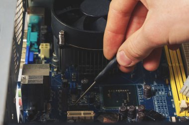 Bilgisayarı tamir eden teknisyenin tornavida aleti ile ellere yakın çekim