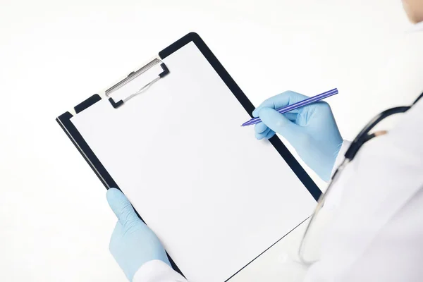 穿着蓝色乳胶手套的医生拿着医用剪贴板,上面有空白纸.卫生保健和医药的概念。空剪贴板模板和复制空间。因白人背景而被隔离 — 图库照片