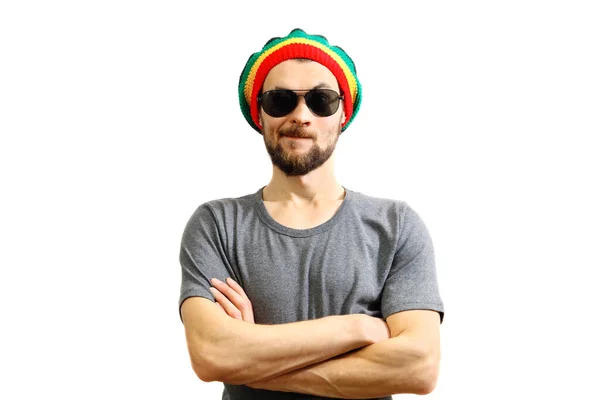 Ung kaukasisk skeptiker man i rasta hatt, solglasögon och grå t-shirt på vit bakgrund — Stockfoto