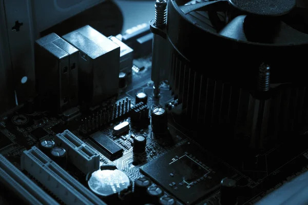 Komponenty na płytce obwodu PC. Chip, wentylator, kondensator i złącza na płycie głównej komputera osobistego. Wewnętrzne zdjęcie w tle — Zdjęcie stockowe