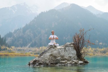 Genç bir adam yoga yapıyor. Agni Stambhasana Egzersizi