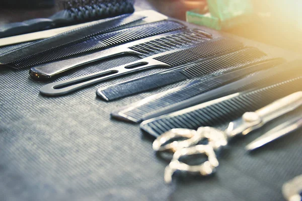 Grzebienie, szczotki i nożyczki na stole u fryzjera — Zdjęcie stockowe