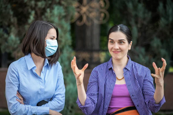 Zwei junge Frauen mit unterschiedlichen Einstellungen zum Coronavirus — Stockfoto