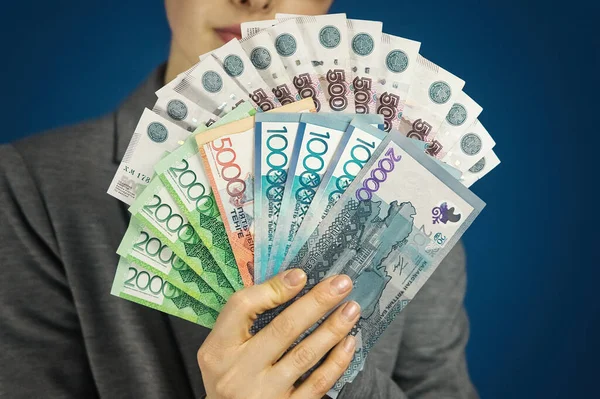 Elinde bir paket Kazakistan tenjanı ve Rus rublesi olan bir kadın. Göçmenlik kavramı. Seçici odak