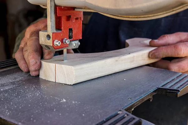 Las manos de los trabajadores de cerca en el taller de carpintería cortan el tronco en tablas usando una sierra de cinta. Madera bruta y artesanía de madera. —  Fotos de Stock