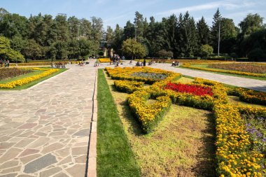 Central City 'nin manzarası Gorky Park meydanı. Çiçekli yatak ve güneşli bir yaz gününde yürüyen insanlar..
