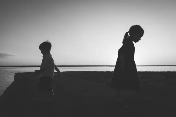 Retrato en blanco y negro de dos niños que salen en diferentes direcciones al aire libre — Foto de Stock