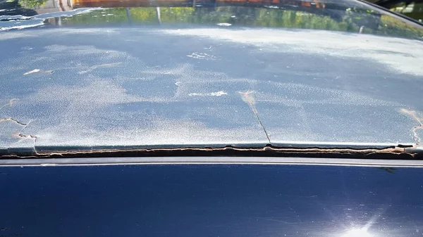 Bad car body repair. The putty is peeling off the metal.