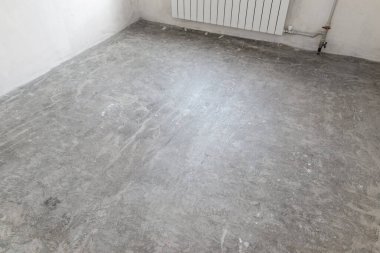 Döşemeyi döşemek için boş odada beton zemin hazırlandı. Kendini dengeleyici karışımla kaplandı..