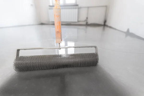 セメントの床の混合物とレベリング 針ローラーで自己レベリングエポキシ バルク床のためのスパイクローラー — ストック写真