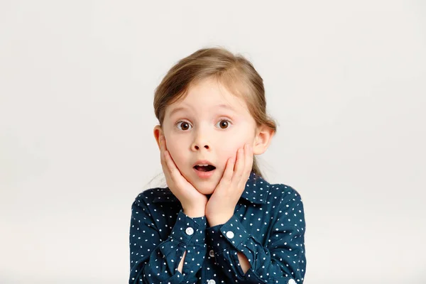 Забавна мила дівчинка з руками близько до обличчя 4-6 років в блакитній сукні з крапками полоки ізольовані на білому — стокове фото
