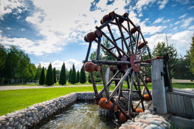 Decorative garden pond with with jugs on a movable wheel on an electric motor