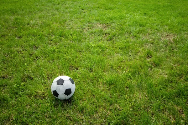 Football soccer ball on green grass field with big copy space — Zdjęcie stockowe