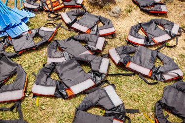 Rafting yaptıktan sonra can yelekleri çimlerde kurur. Ekstrem sporlar için güvenlik ekipmanı.