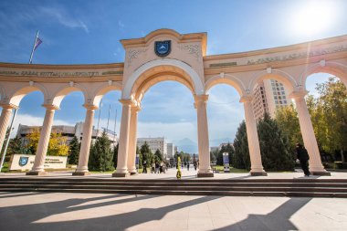 Üniversitenin adı ve açık mavi gökyüzü olan görkemli beyaz kemerin yakın çekimi. Almaty, Kazakistan - 30 Eylül 2024