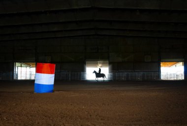 Woman on horseback Silhouette In Barrel Racing Arena clipart