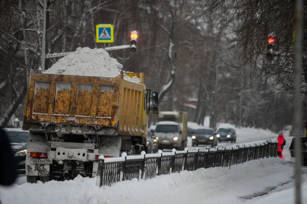 Snow plow and snow truck cleaning the streets during a snow storm in night maintenance action in Belgrade, Serbia