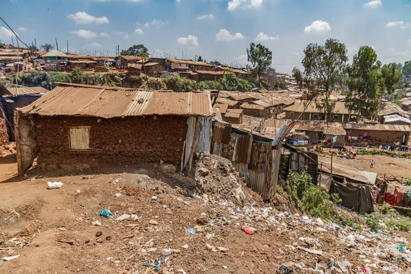 A home in the slum of Kibera surrounded by trash and other homes.