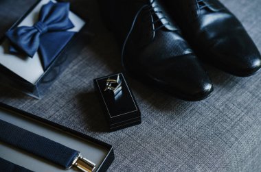 Şık ve alışılmadık bir düğün. Damadın ayakkabıları, papyon ve kol düğmeleri.