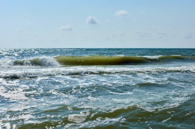 Bulutlu mavi gökyüzüne karşı sakin deniz suları