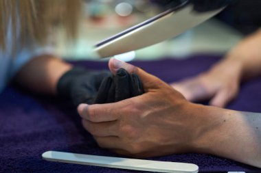 Manikür aracı kullanan profesyonel bir manikür sürecinin fotoğrafı