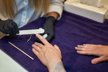 Manikür aracı kullanan profesyonel bir manikür sürecinin fotoğrafı