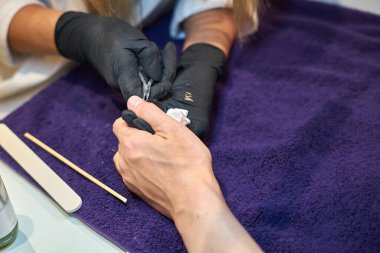 Manikür aracı kullanan profesyonel bir manikür sürecinin fotoğrafı