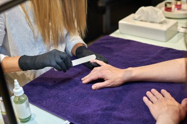 Manikür aracı kullanan profesyonel bir manikür sürecinin fotoğrafı