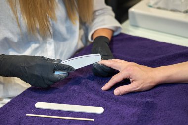 Manikür aracı kullanan profesyonel bir manikür sürecinin fotoğrafı