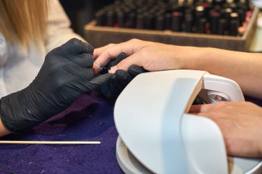 Manikür aracı kullanan profesyonel bir manikür sürecinin fotoğrafı