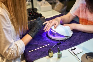 Manikür aracı kullanan profesyonel bir manikür sürecinin fotoğrafı