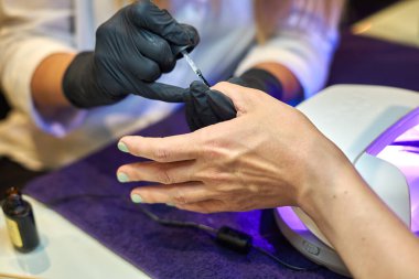 Manikür aracı kullanan profesyonel bir manikür sürecinin fotoğrafı