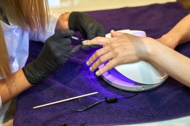 Manikür aracı kullanan profesyonel bir manikür sürecinin fotoğrafı