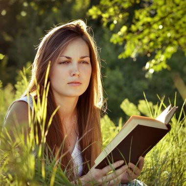 Güzel kız bir çayır üzerine bir kitap okuma