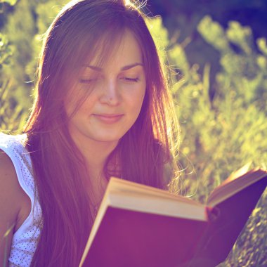 Güzel kız bir çayır üzerine bir kitap okuma