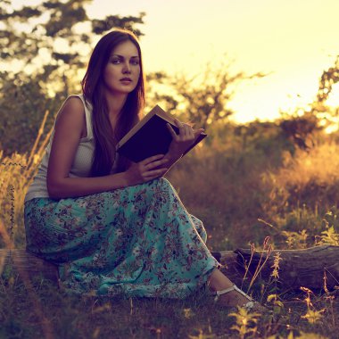 Güzel kız bir çayır üzerine bir kitap okuma