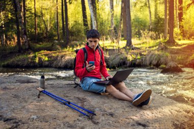 Dizüstü bilgisayar ve telefon çalışma kırmızı ceketli adam.