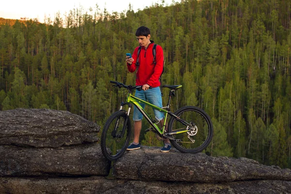 Cycliste sur une falaise, la forêt en arrière-plan — Photo