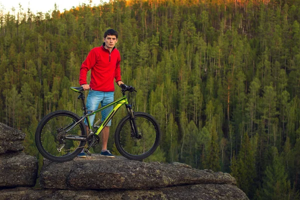 Cycliste sur une falaise, la forêt en arrière-plan — Photo