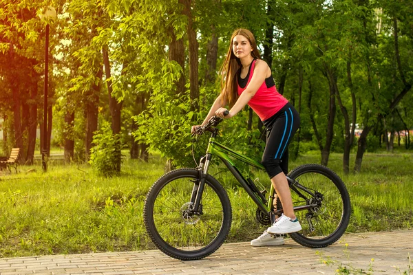 Happy girl over a bicycle in the park — Stock Photo, Image