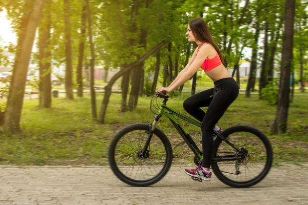 Boldog lány a parkban a kerékpár felett — Stock Fotó