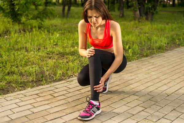 Woman in pain while running in park — Stock Photo, Image