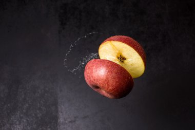 yarım kırmızı elma havada su sıçramalarına