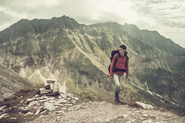 Mann erklimmt Berg bei schönem Ausblick — Stockfoto