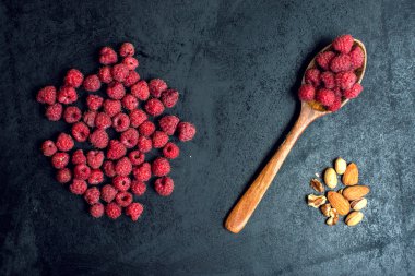 koyu arka plan üzerine bir kaşık içinde ahududu