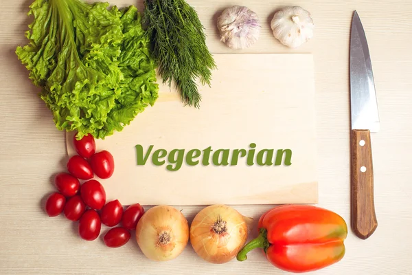 Vegetables, chopping board and knife on a table — Stock Photo, Image