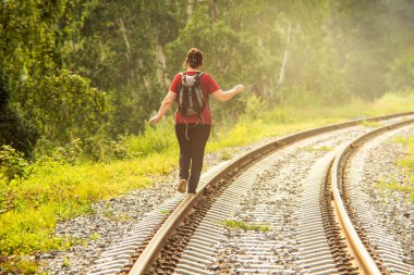 Demiryolu üzerinde gidiş bir sırt çantası ile kadın uzun yürüyüşe çıkan kimse